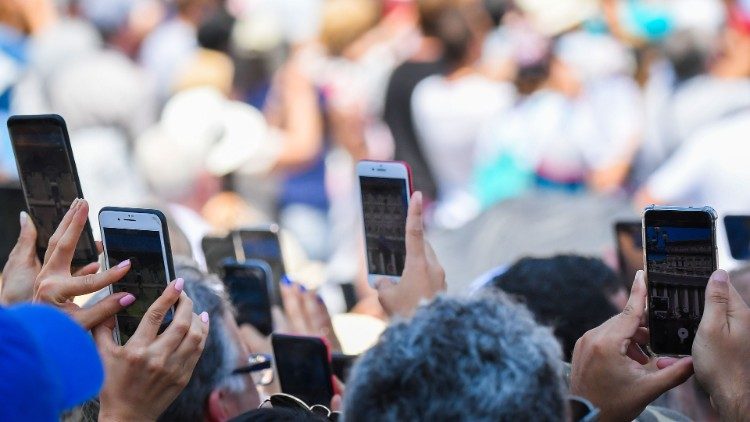 Fiéis com seus celulares durante o Angelus