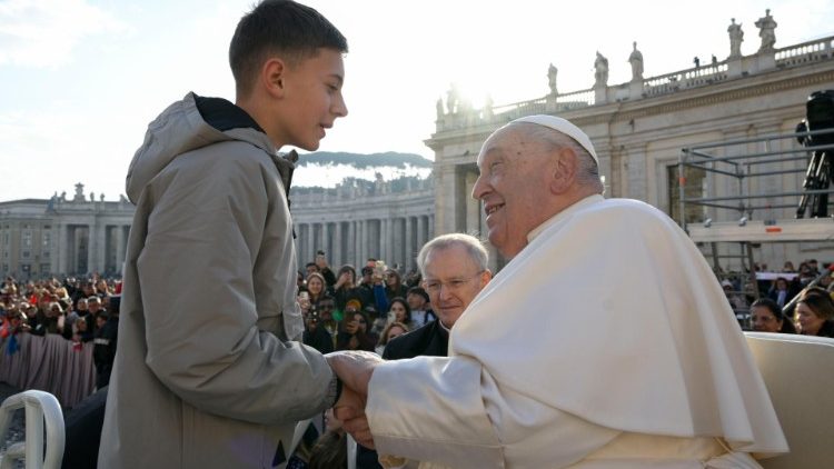 Papa saúda um jovem durante o trajeto com o papamóvel 